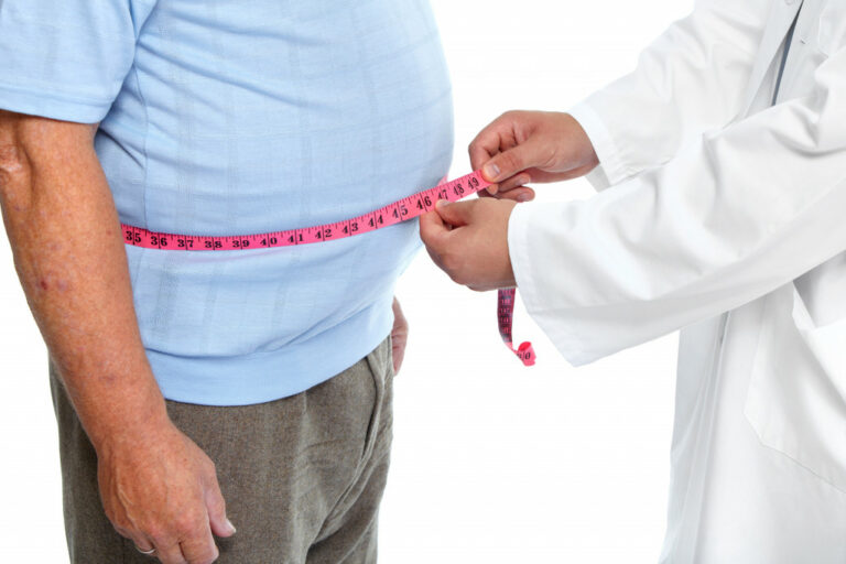 An overweight person checking waistline